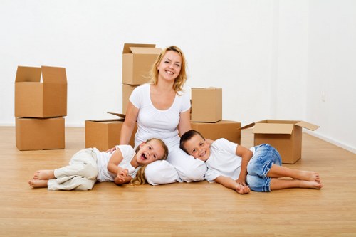 Local movers handling boxes and furniture in a North London property