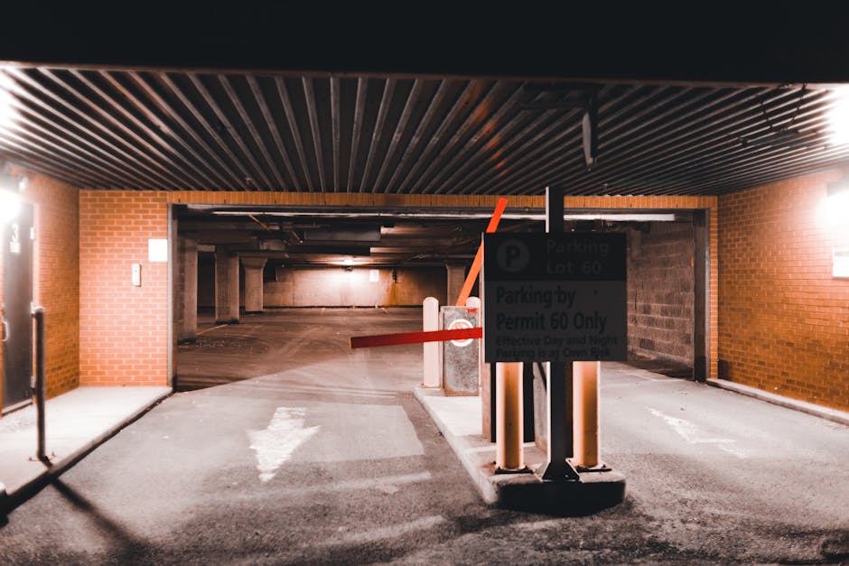 Photograph of a white metal sign attached to a textured brown stone wall, displaying the message 'PARKING WITH HOTEL PERMIT ONLY' in bold black letters. The sign is secured with four screws, one at ea